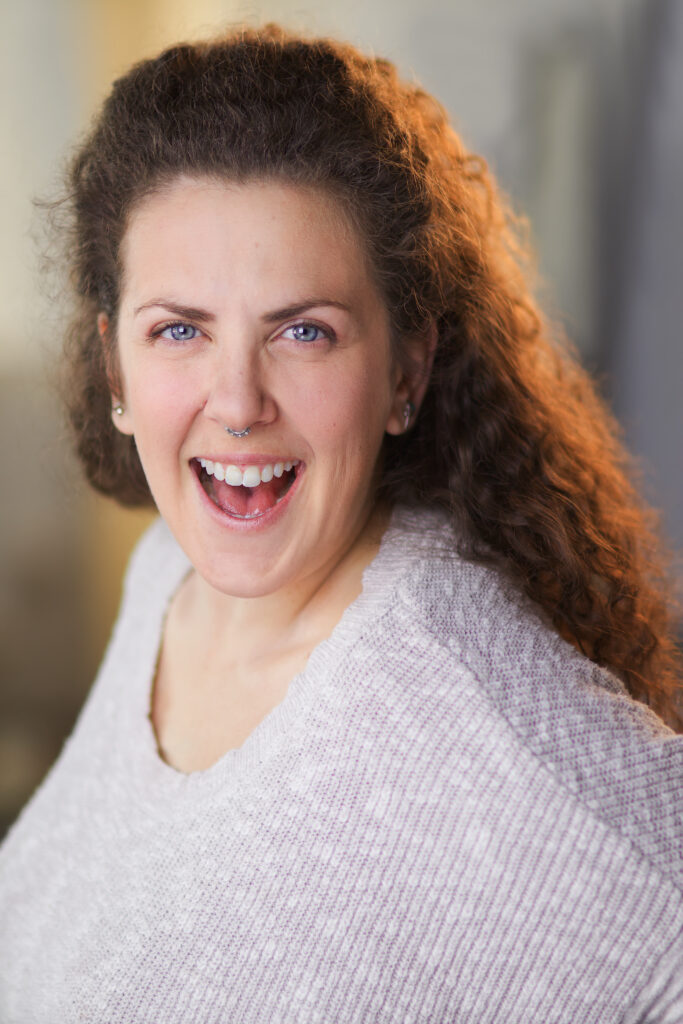 A woman with long hair and big smile.